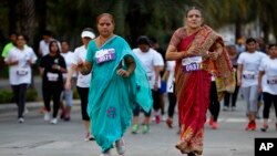 Para perempuan setengah baya India mengikuti lari 5K untuk memperingati 'Hari Perempuan Internasional' di Bangalore, India, Minggu (8/3).