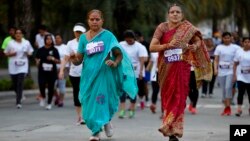 Middle-aged women in traditional Indian attire run along with youngsters during a 5-kilometer run, organized to celebrate International Women's Day in Bangalore, India, March 8, 2015.