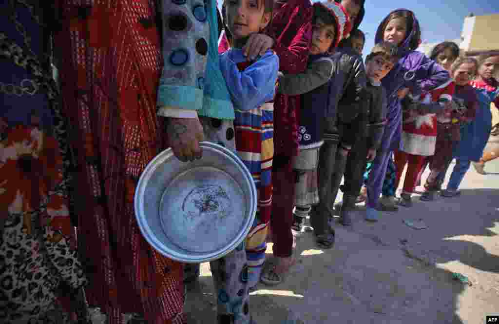 Displaced Iraqi children stand in line to receive food rations in Mosul&#39;s western Tal al-Rumman neighborhood, during an offensive to retake the western parts of the city from the jihadists.