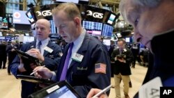 Traders Patrick Casey, left, Michael Smyth, center, and Richard Newman work on the floor of the New York Stock Exchange, Feb. 7, 2018. 