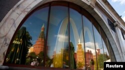 The walls and towers of the Kremlin are reflected in a window of a closed McDonald's restaurant, one of four temporarily closed by the state food safety watchdog, in Moscow, Aug. 21, 2014.