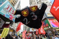 FILE - A sign in the shape of a hand with the colors of the China national flag for fingernails and a "23" on its palm with reference to the controversial Article 23 law, is carried by protesters at a rally in Hong Kong, Oct. 1, 2018.