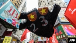 FILE - A sign in the shape of a hand with the colors of the Chinese national flag for fingernails and a "23" on its palm with reference to the controversial Article 23 law is carried by protesters at a rally in Hong Kong, Oct. 1, 2018.