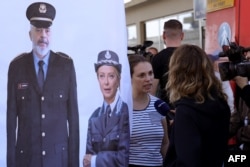 Civil rights activists gather in protest after a group of migrants intercepted in Italian waters arrived at Shengjin port in Albania on Oct. 16, 2024. The banner depicts the prime ministers of Albania, Edi Rama, and Italy, Giorgia Meloni.