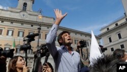 Five-Star Movement Lawmaker Alessandro Di Battista uses a megaphone to talk with demonstrators of the Liberation of Italy Movement as they stage a protest outside the Italian Parliament against the government-proposed electoral law "Rosatellum" in Rome, Oct. 10, 2017.