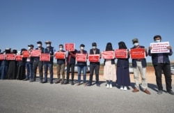 FILE - A human chain is formed by workers from the civil society, humanitarian aid, and medical and rescue services in support of aid into Syria's rebel-held province of Idlib through the Bab al-Hawa border crossing with Turkey, July 2, 2021.