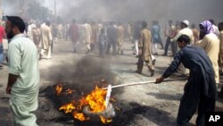 Pakistani protesters burn tires to block the main highway in Rawalpindi, Pakistan, September 21, 2012.