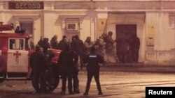 Members of a police special operations unit gather outside a post office, where a man took people hostage, in Kharkiv, Ukraine, Dec. 30, 2017.