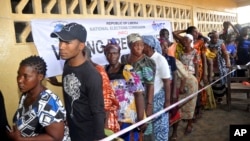 People wait to cast their votes during a Presidential election in Monrovia, Liberia, Oct. 10, 2017. Liberians head to the polls, Dec. 25, 2017, for a runoff election between a former international soccer star and the vice president to replace Africa's first female head of state.