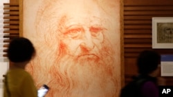 Visitors look at a portrait drawing of Italian Renaissance painter, scientist and inventor Leonardo Da Vinci during a permanent exhibition on Da Vinci, on the exact day commemorating the 500th anniversary of his death, in Rome, Thursday, May 2, 2019. 