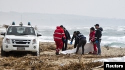 FILE: Rescuers recover a body after a suspected migrant boat is wrecked and bodies believed to be of refugees were found in Cutro, the eastern coast of Italy's Calabria region, Italy. Taken Feb. 26, 2023.