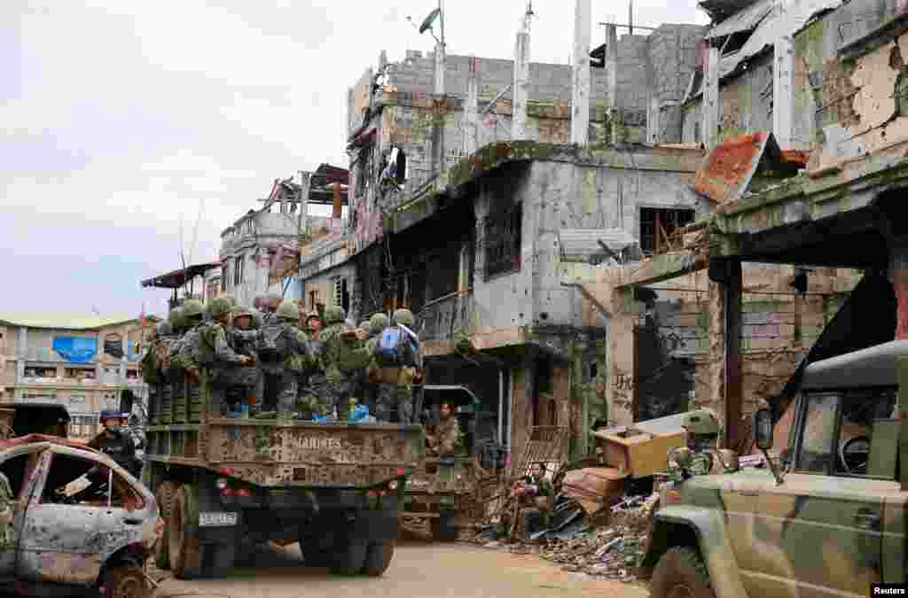 A military truck full of government soldiers move past damaged houses and buildings as troops continue clearing operations against the pro-IS militant group which seized Mapandi district in Marawi city, southern Philippines.