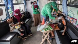 Seorang anak tuna wisma sedang menerima perawatan di layanan klinik keliling dari pemerintah Mesir, 22 Juni 2020. (Foto: AFP)