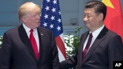 FILE - , U.S. President Donald Trump, left, and Chinese President Xi Jinping arrive for a meeting on the sidelines of the G-20 Summit in Hamburg, Germany.