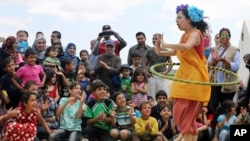 In this June 6, 2014 photo, Lebanese clown Sabine Choucair, a member of "Clowns Without Borders," performs for children at a Syrian refugee camp in the eastern town of Chtoura, in Bekaa valley, Lebanon. 