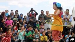 Badut Lebanon Sabine Choucair, anggota "Clowns Without Borders," tampil menghibur anak-anak di kamp pengungsi Suriah di Chtoura, di lembah Bekaa, Lebanon. (AP/Bilal Hussein)