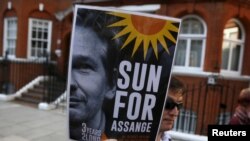 Un simpatizante de Julian Assange muestra un cartel en el que pide "luz de sol para Assange", frente a la embajada de Ecuador en Londres.