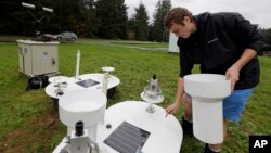 Brandon Jameson, a ground validation engineer, adjusts a rain gauge located at the Quinault National Fish Hatchery, near Humptulips, Wash., Nov. 6, 2015.