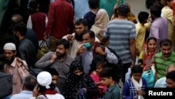 A man wears a protective mask as a preventive measure against coronavirus, while walks with others to board a train at the Cantonment railway station in Karachi, Pakistan, March 15, 2020. 