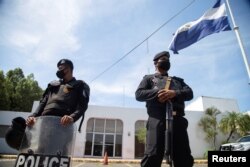 Nicaraguan police stand watch during a raid at La Prensa, the only national newspaper, after President Daniel Ortega's government opened customs fraud and money laundering investigations against the publication, in Managua, Aug. 13, 2021.