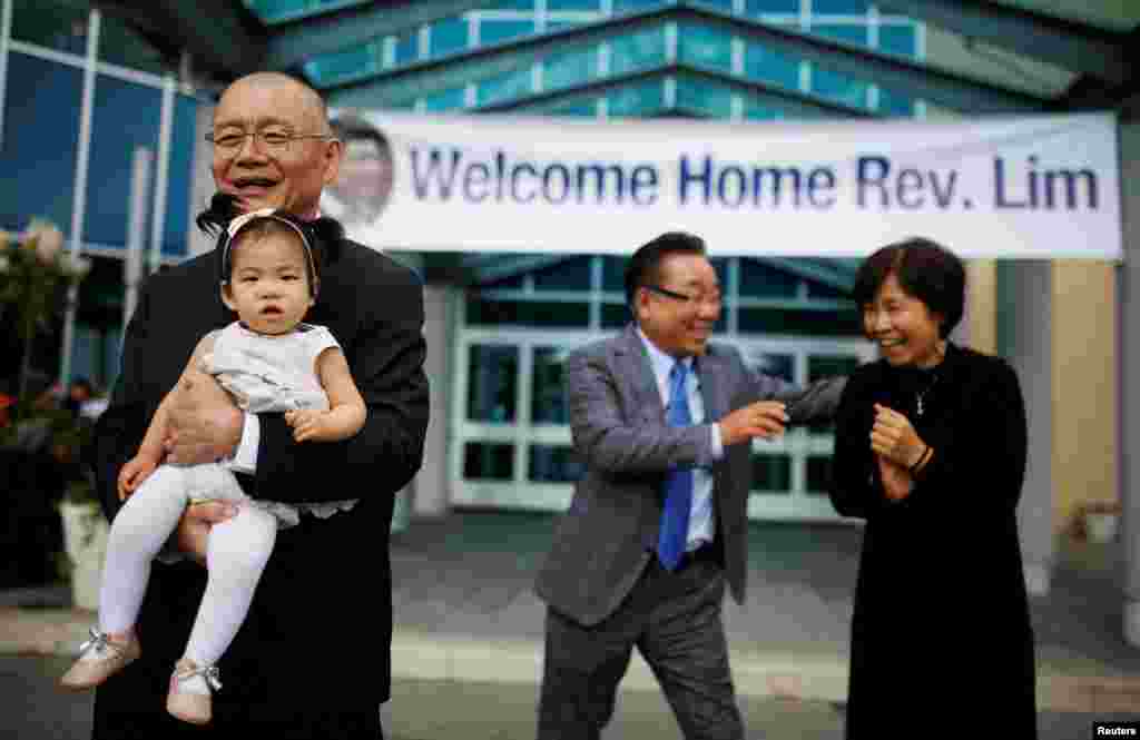 Pastor Hyeon Soo Lim, who returned to Canada from North Korea after being held for 31 months, holds his granddaughter in front of his wife Geum Young Lim, as he leaves the Light Presbyterian Church in Mississauga, Ontario, Canada, Aug. 13, 2017.