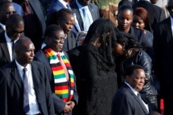 Zimbabwean President Emmerson Mnangagwa stands next to Grace Mugabe, after receiving the body of her husband, former Zimbabwean President Robert Mugabe in Harare, Zimbabwe, Sept. 11, 2019.