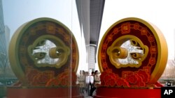 北京一家高级消费中心店门口展示中国富豪们喜欢的寓意富足的金猪装饰。（美联社资料照）