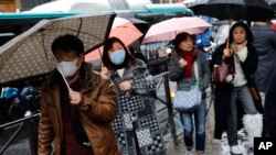 People, some wearing a mask, walk in Paris, March 2, 2020. 