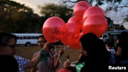 Mujeres escriben en globos los nombres de mujeres asesinadas para una marcha de protesta en San Salvador, el 19 de febrero de 2020, en recuerdo de Fátima Cecilia Aldrighett, de 7 años, quien desapareció y su cuerpo fue hallado en una bolsa de plástico en México.