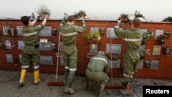 Austrian fire fighters move flower pots as they clean mud from the columbarium at the cemetery in the Austrian-German border town of Schaerding, along the flooded river Inn June 5, 2013. Torrential rain in the south and south-east of Germany caused heavy 