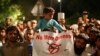 FILE - A boy holds a banner while sitting on his father's shoulder attending a rally called by the Pakistan Defense Council, a coalition of Islamic parties, in Lahore, Pakistan, June 12, 2016. Hundreds of supporters of the coalition rallied in Lahore against U.S. drone strikes in Pakistani areas.