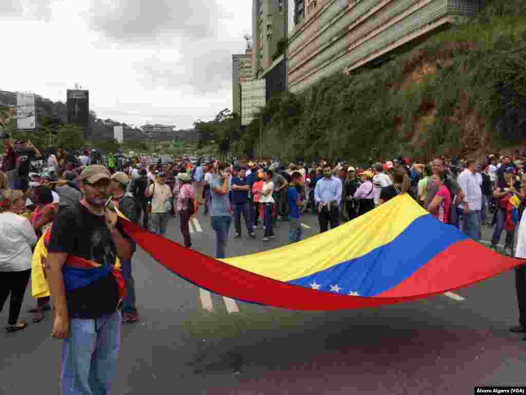 دارالحکومت کراکس میں حزب مخالف کے حامیوں نے پرچم اُٹھا رکھے ہیں۔