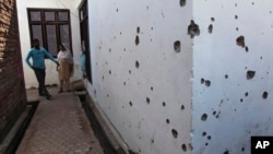  FILE - Indian villagers look at one of the houses damaged in firing by Pakistani troops at Village Nanga, in the Ramgarh sector of Jammu and Kashmir state, India, Oct. 9, 2014.