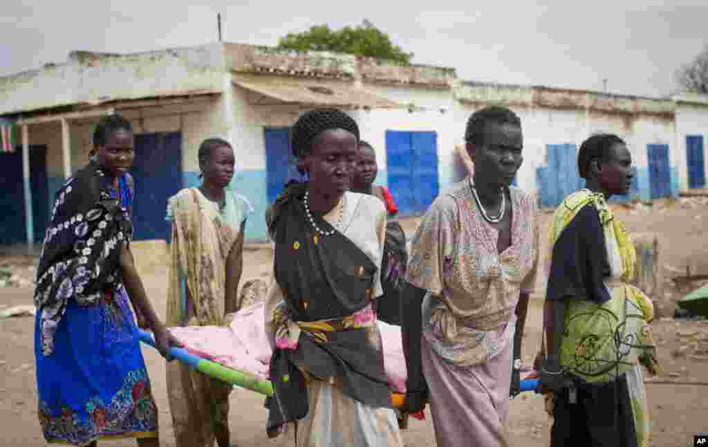 Para perempuan membawa mayat seorang warga sipil yang tewas di pusat kota Malakal, negara bagian Upper Nile di Sudan Selatan, 21 Januari 2014. 