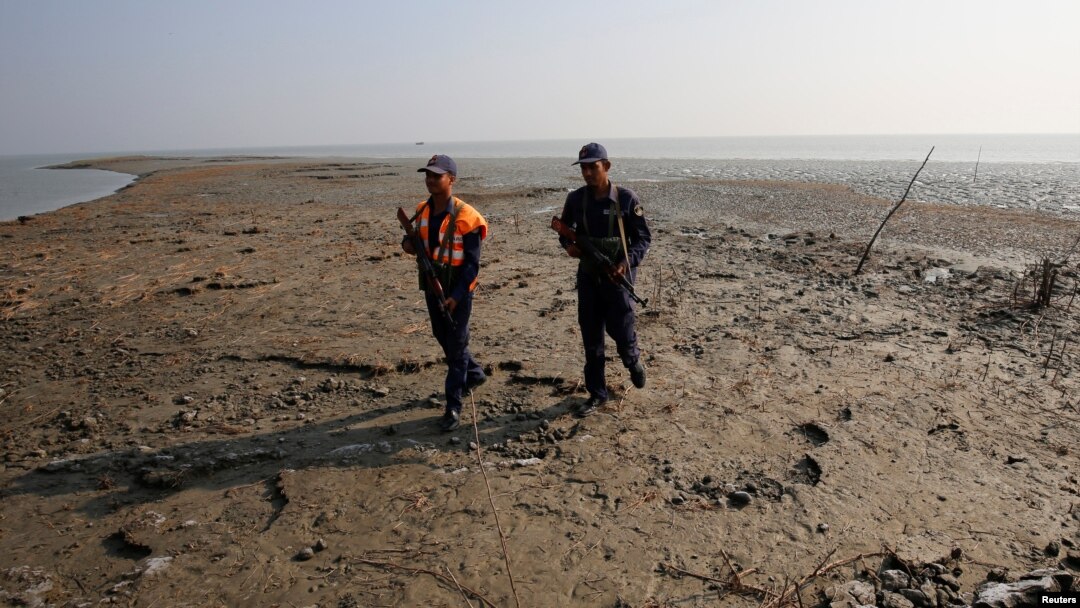 Bangladesh coast guards walk in the Thengar Char island in the Bay of Bengal, Bangladesh, Feb. 2, 2017.