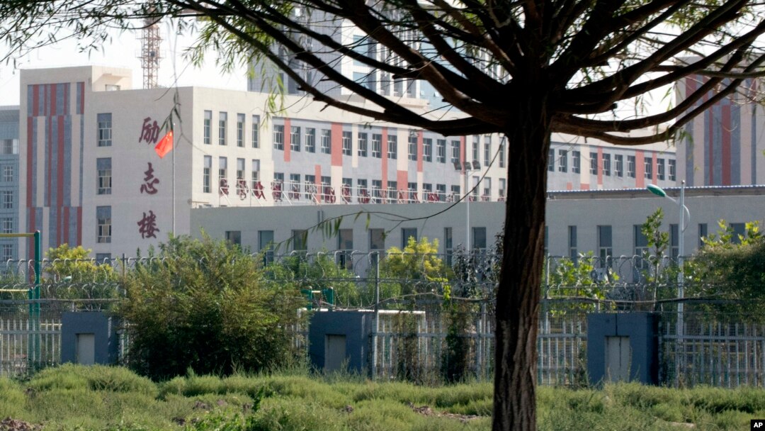 FILE - Barbed wire protects the walls around a cluster of schools on the outskirts of Kashgar, in western China's Xinjiang region, Aug. 31, 2018.
