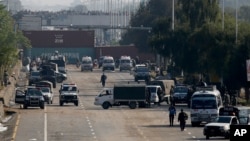 Security vehicles park near shipping containers placed by authorities on a highway to stop supporters of the 'Tehreek-e-Labaik Pakistan, a religious political party, entering into the capital during an anti-France rally in Islamabad, Nov. 16, 2020.