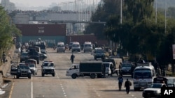 Security vehicles park near shipping containers placed by authorities on a highway to stop supporters of the 'Tehreek-e-Labaik Pakistan, a religious political party, entering into the capital during an anti-France rally in Islamabad, Nov. 16, 2020.