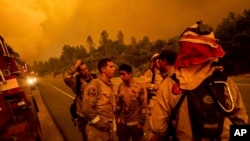 Petugas pemadam kebakaran mendiskusikan rencana pemadaman kebakaran yang dijuluki "Carr Fire" di Shasta, California, Kamis, 26 Juli 2018.