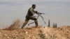 FILE - A Shi'ite fighter clashes with members of the Sunni-dominated Free Syrian Army rebel in the town of Hatita, in the countryside of Damascus, Syria, Nov. 22, 2013.