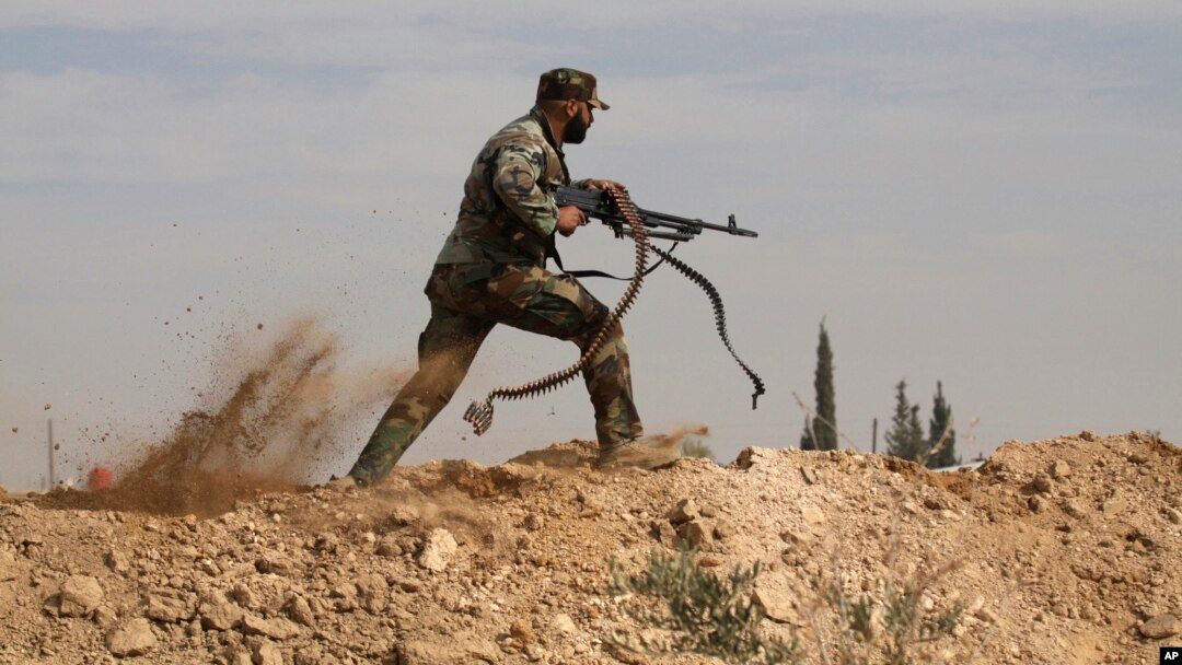 FILE - A Shi'ite fighter clashes with members of the Sunni-dominated Free Syrian Army rebel in the town of Hatita, in the countryside of Damascus, Syria, Nov. 22, 2013.