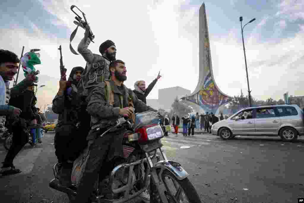 Syrian opposition fighters celebrate the fall of the Syrian government, in Damascus, Dec. 8, 2024.&nbsp;The Syrian government fell in a stunning end to the 50-year rule of the Assad family after a sudden rebel offensive sprinted across government-held territory and entered the capital in 10 days.