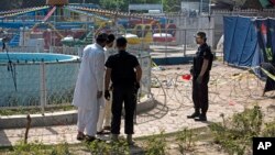 Pakistani police commandos and security personnel cordon off the area of Sunday's bombing at an amusement park in Lahore, Pakistan, March 28, 2016.