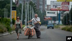 Cư dân dùng xe đạp chở theo đồ đạc rời khỏi Slovyansk, miền đông Ukraine, ngày 9/6/2014.