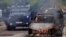 Agentes de las fuerzas policiales de Kosovo actúan en medio de enfrentamientos con manifestantes de la población serbia en esa nación, mientras un automóvil se incinera, en el pueblo de Zvecan, el viernes 26 de mayo de 2023.