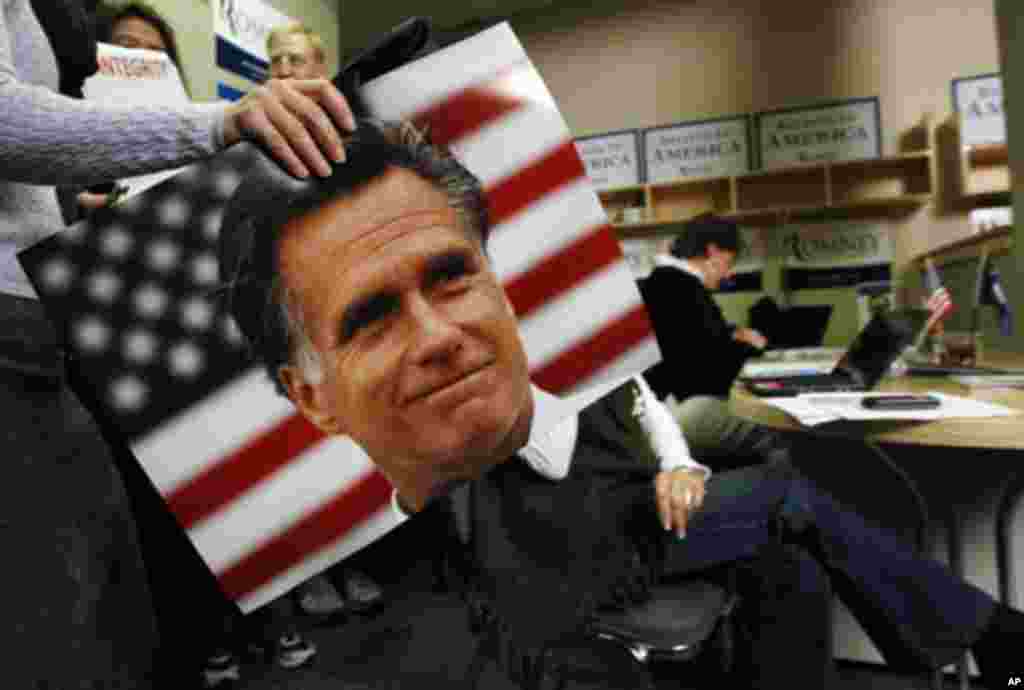 A supporter of U.S. Republican presidential candidate and former Massachusetts Governor Mitt Romney carries a photo of Romney past a campaign worker calling potential voters in Greenville, South Carolina, January 21, 2012. REUTERS/Jim Young (UNITED S