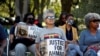 Personas con carteles se reúnen frente al Palacio de Justicia del Condado de Glynn por el juicio por el asesinato de Ahmaud Arbery, en Brunswick, Georgia, Estados Unidos, el 18 de octubre de 2021.