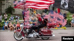 Spectators line the street as Harley riders participate in the Harley Davidson 110th Anniversary Celebration parade in Milwaukee, Wisconsin on Labor Day weekend, August 31, 2013. 