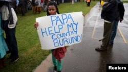 Une femme porte une pancarte "Papa, aide mon pays le Burundi" avant une messe a Nairobi du Pape Francois au Kenya. Nov 26, 2015. REUTERS/Goran Tomasevic - RTX1VX5V