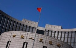 FILE - A Chinese national flag flutters outside the headquarters of the People's Bank of China, the Chinese central bank, in Beijing.